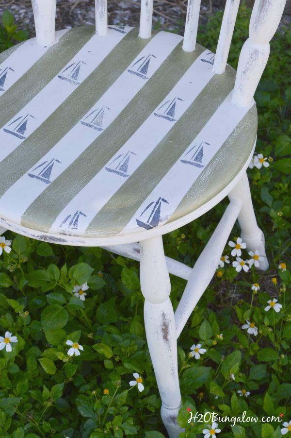 DIY nautical accent chair makeover. Furniture painting tutorial for stripes and sailboat stenciling with resource list. Make your own coastal accent chair. Find more home decor tutorials at H2OBungalow.com