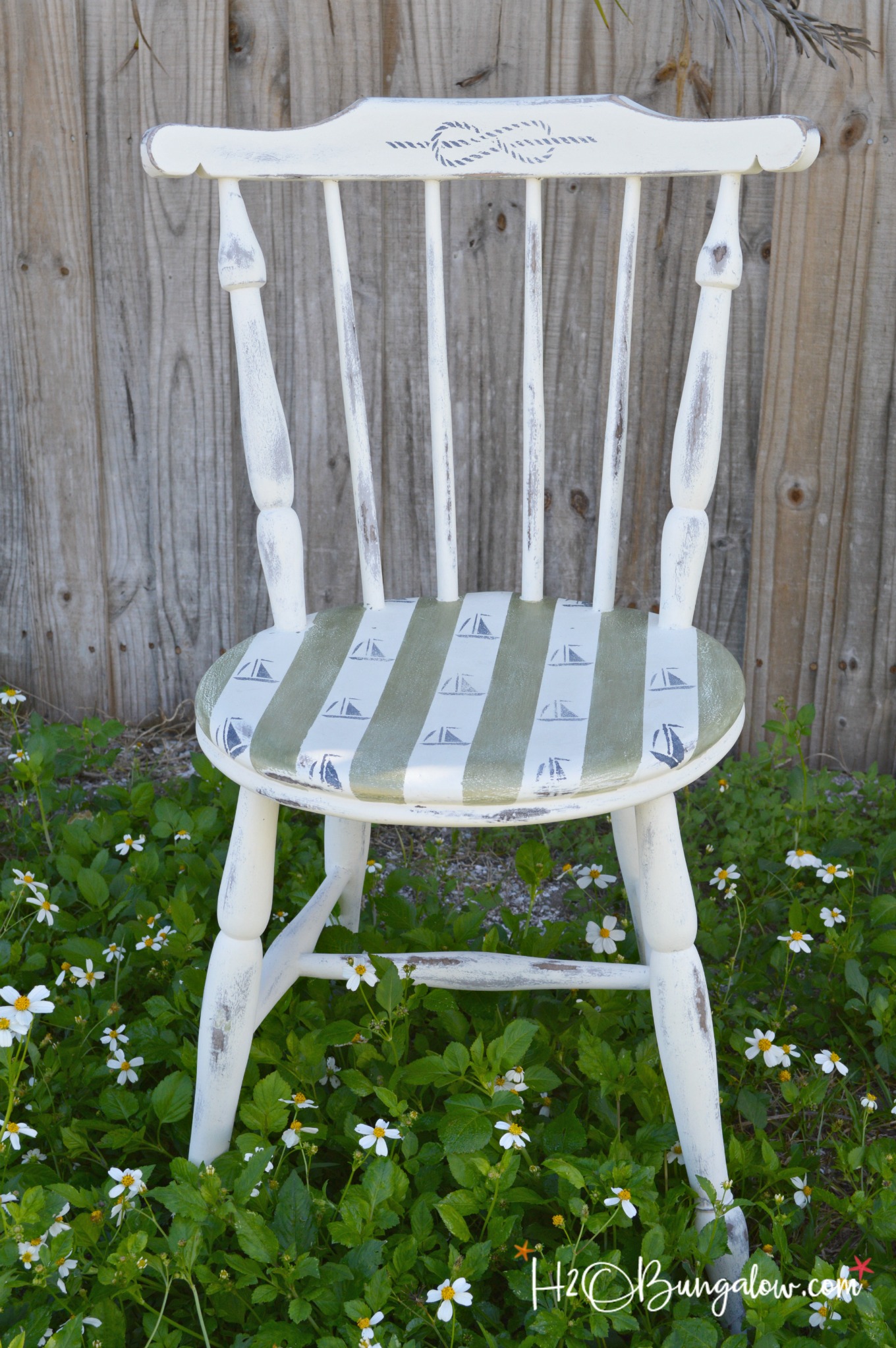 DIY nautical accent chair makeover. Furniture painting tutorial for stripes and sailboat stenciling with resource list. Make your own coastal accent chair. Find more home decor tutorials at H2OBungalow.com