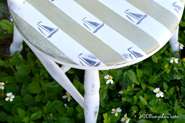 DIY nautical accent chair makeover. Furniture painting tutorial for stripes and sailboat stenciling with resource list. Make your own coastal accent chair. Find more home decor tutorials at H2OBungalow.com