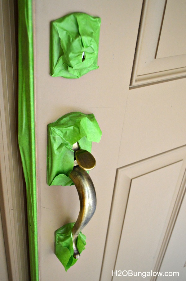 Front door hardware taped off with painters tape.