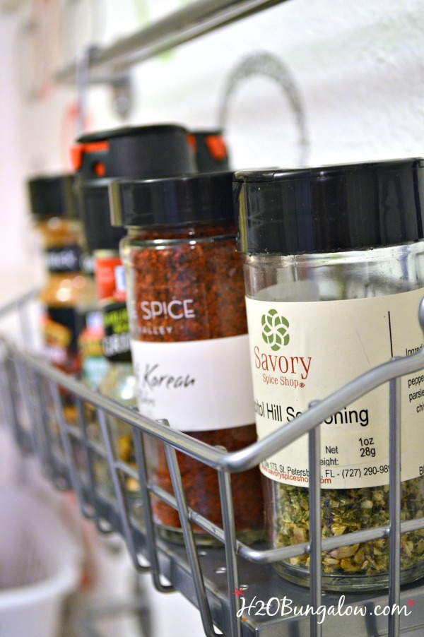 Organizes spices in unused space...a wall! Use these nifty racks to hold and keep your spices easy to see and reach. This soultion freed up a huge amount of space in my kitchen storage www.H2OBungalow.com #organize #smallhomesolution