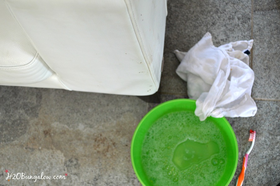 Green bowl with cleaning solution, toothbrush, and white cloth