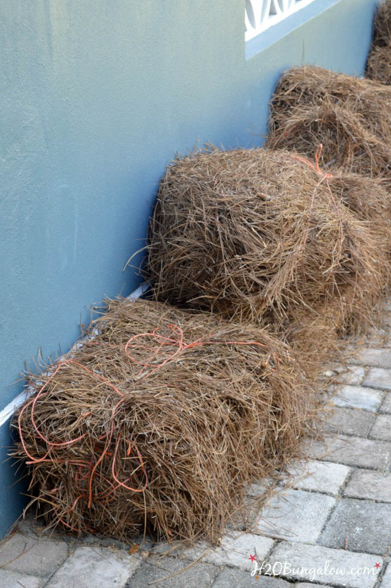 bales of landscaping straw sitting next to the house