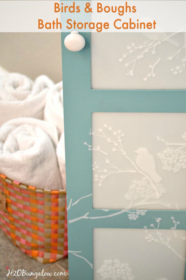 Updated bath storage cabinet with DIY frosted glass inserts and cascading stenciled birds and twigs. It looks fresh and clean look in our new master bath www.H2OBungalw.com #ThemedFurnitureMakeoverDay #paintedfurniture