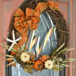 Make a simple and festive monogram fall wreath with starfish, acorns and pumkins. Tuck sprigs of greenery into the grapevine wreath for filler. See this and 32 more fall projects in the Fall Ideas Tour. www.H2OBungalow.com #Fallwreath "Falldecor #FallIdeasTour