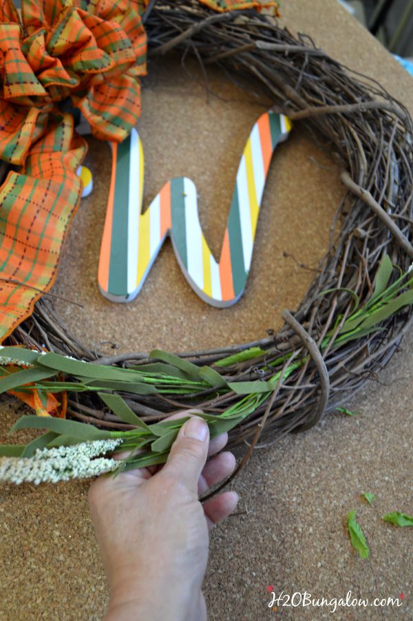 Make a simple and festive monogram fall wreath with starfish, acorns and pumkins. Tuck sprigs of greenery into the grapevine wreath for filler. See this and 30 more fall projects in the Fall Ideas Tour. www.H2OBungalow.com #Fallwreath "Falldecor #FallIdeasTour