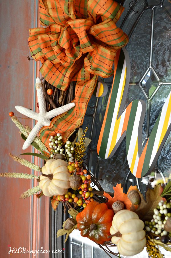 Make a simple and festive monogram fall wreath with starfish, acorns and pumkins. Tuck sprigs of greenery into the grapevine wreath for filler. See this and 30 more fall projects in the Fall Ideas Tour. www.H2OBungalow.com #Fallwreath "Falldecor #FallIdeasTour