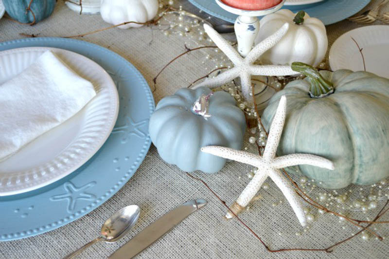 blue and white place setting with painted pumpkins and white starfish