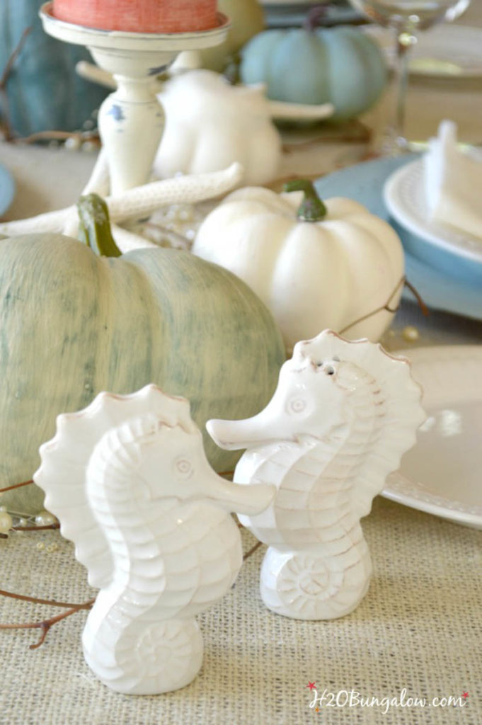 two seahorses in front of painted pumpkins 