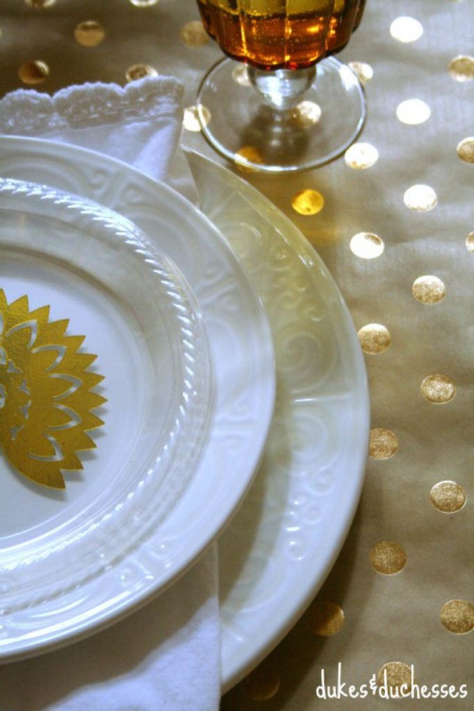 white place setting with metallic turkey place card and metallic polka got table cloth