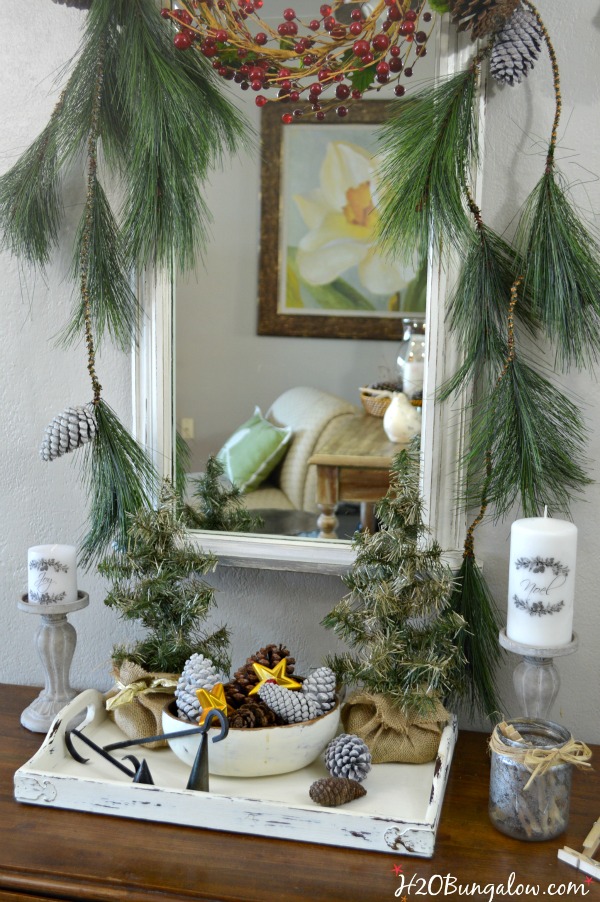 My festive holiday entry makes good use of an entry table in a tight space to stage a warm welcome with a multi-purpose vignette, Christmas cards hang nicely on the metal ladder and a bucket of lap blankets are perfect for a chilly night add to a pretty entry with simple decor. www.H2OBungalow.com #Smallspace 