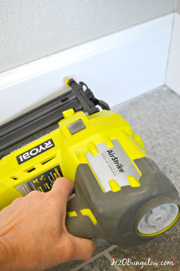 Use brad nailer to attach wood baseboard