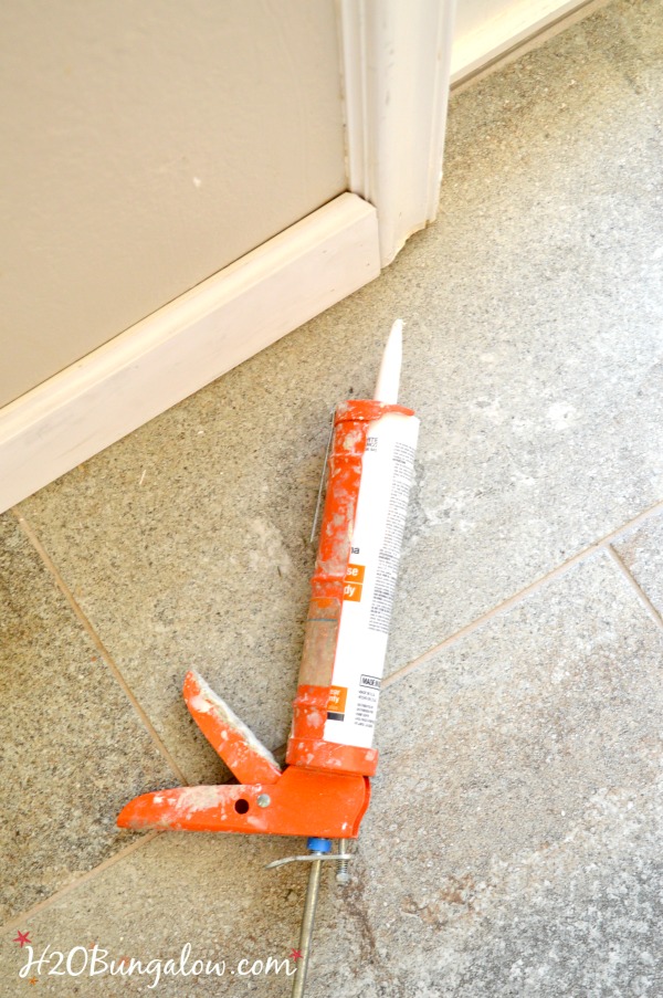  caulk gun shown being used to seal baseboard edges 