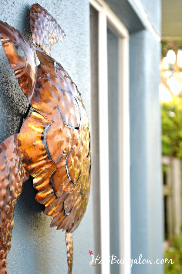 close up of metal turtle hung on house