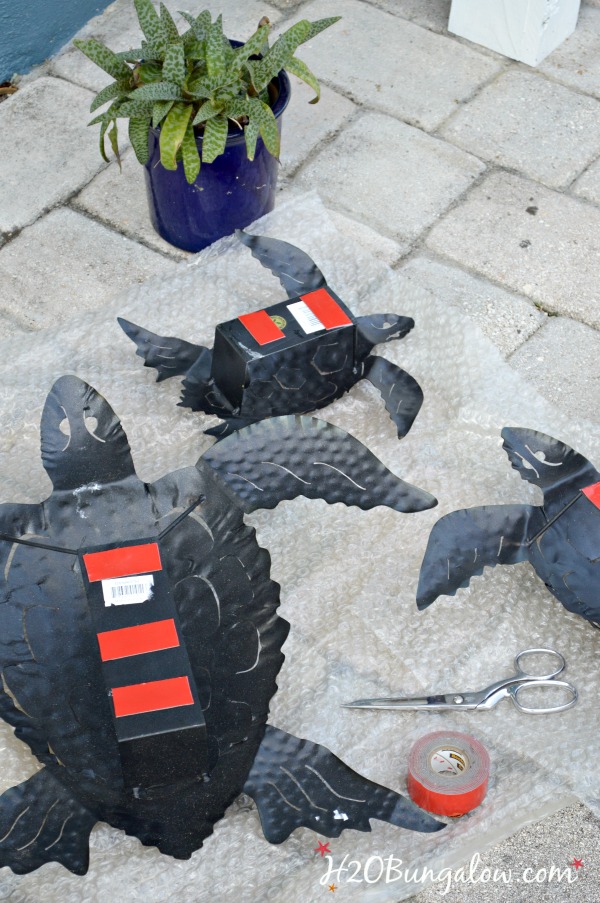 three metal turtles shown upside down for hanging