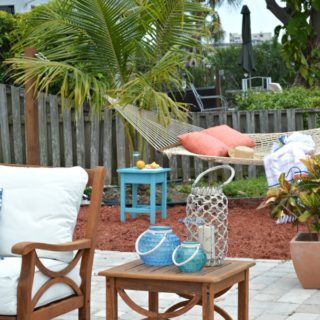 outdoor patio with teak side table and chair and DIY hammock stand in the back