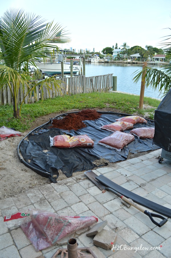 landscaping outdoor space, bags of mulch laying on black weed barrier