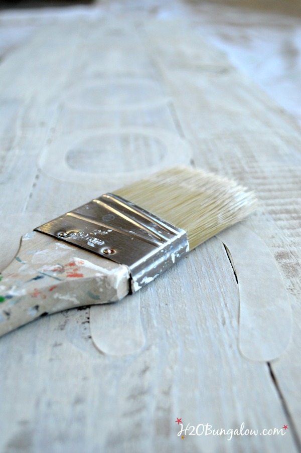 Paint brush laying on dry brushed wood.