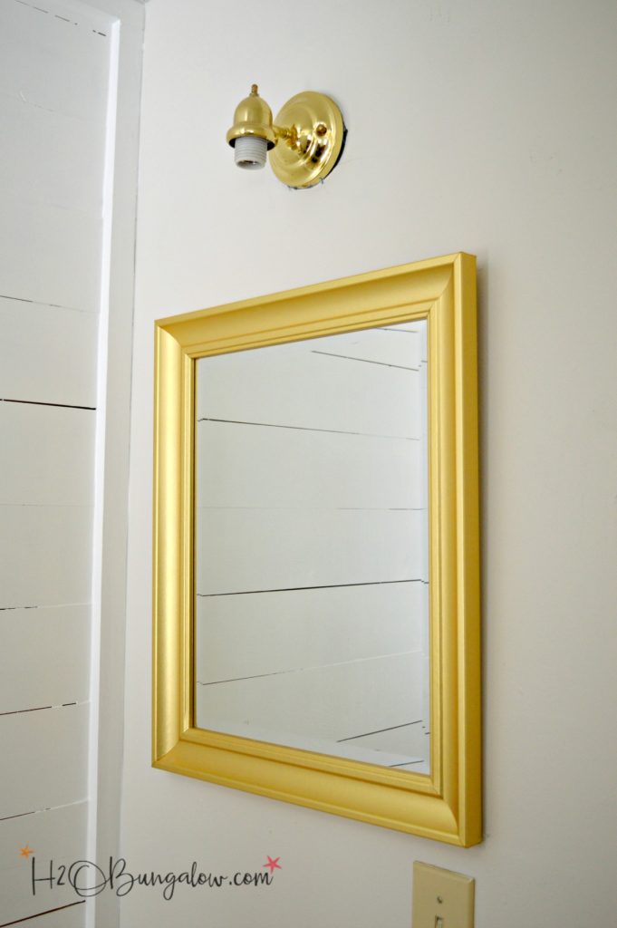 bathroom mirror and light fixture in brass