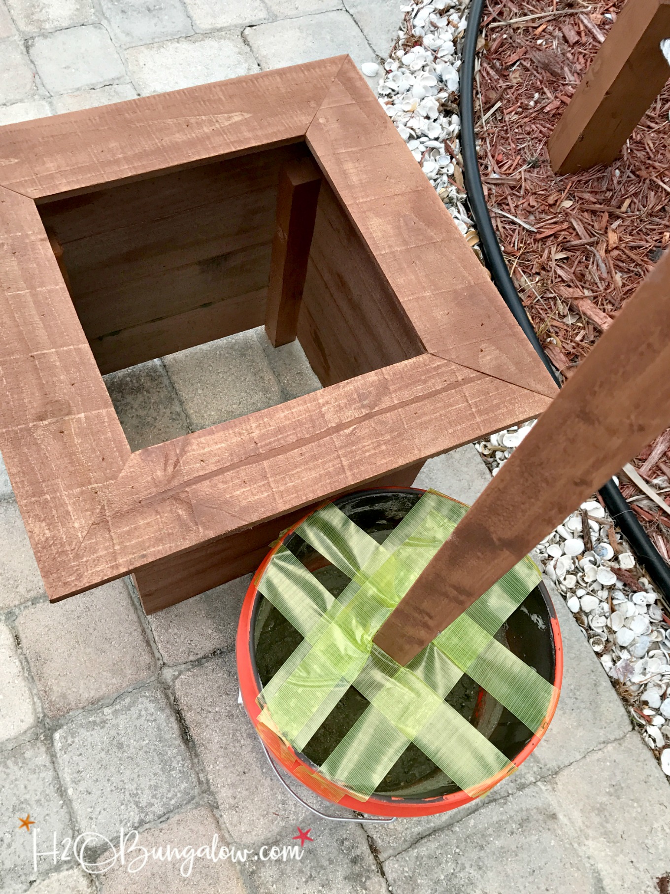 concrete mixed in anchor bucket with green tape holding pole.