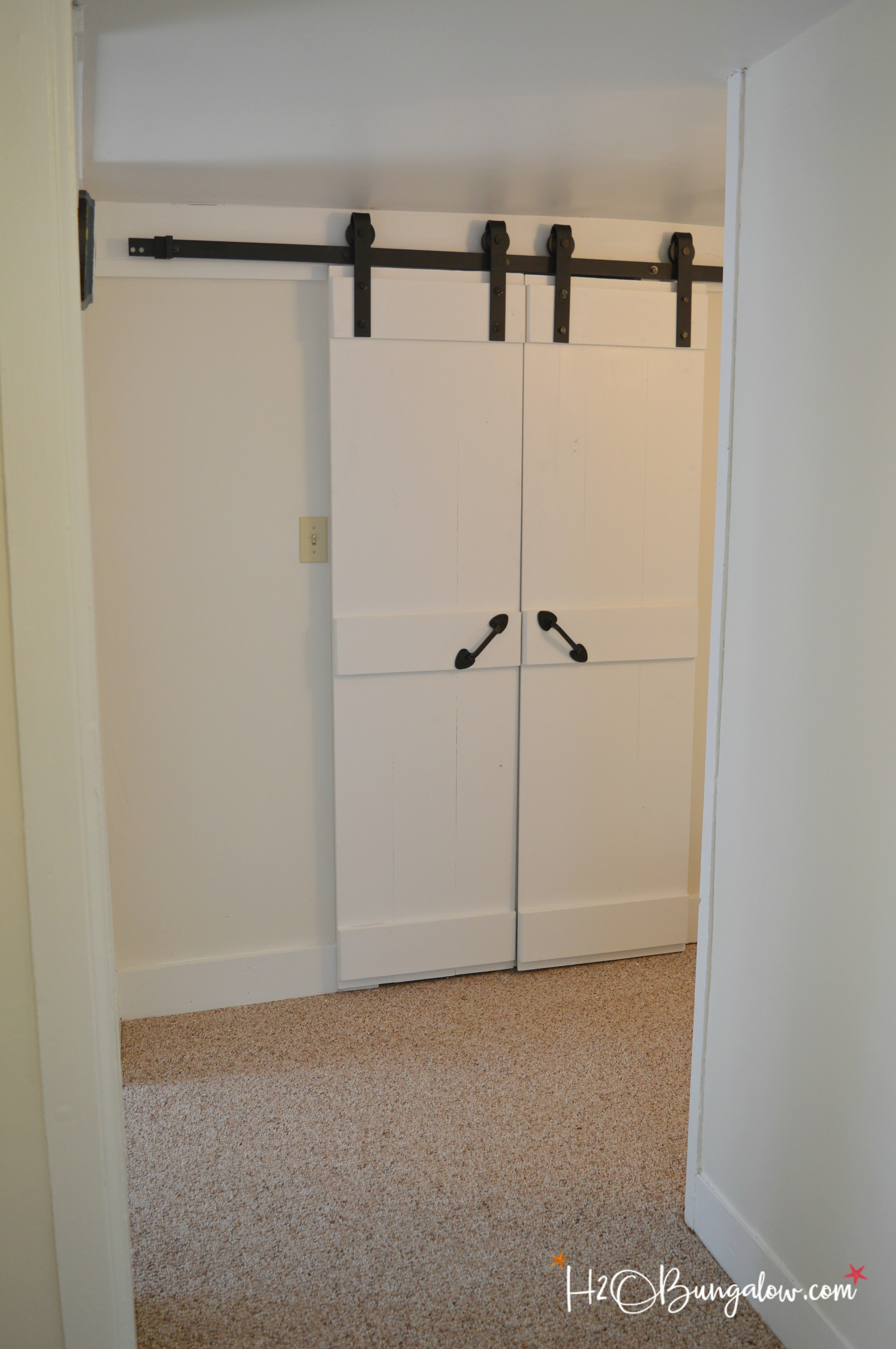 Easy DIY double barn door tutorial for interior sliding barn doors with a budget friendly resource for all sizes of barn door hardware. Make these in a day and update your home. Great for small spaces and bathrooms. 