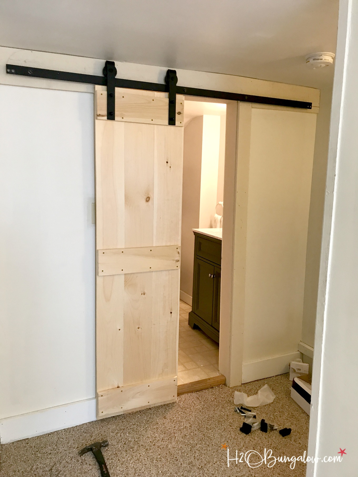 Easy DIY double barn door tutorial for interior sliding barn doors with a budget friendly resource for all sizes of barn door hardware. Make these in a day and update your home. Great for small spaces and bathrooms. 