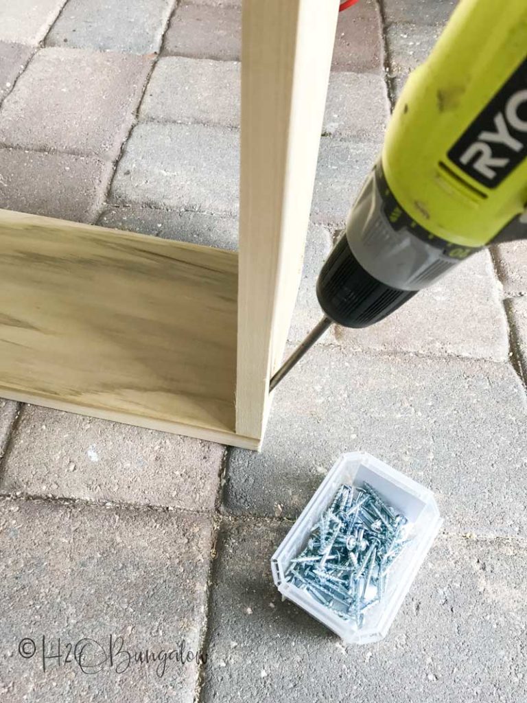 screwing cabinet together with Ryobi drill and container of screws