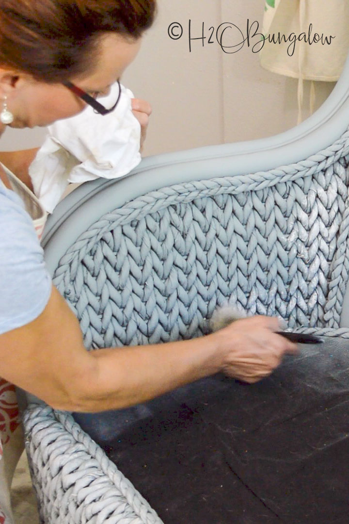 apply paint by hand for detail to wicker chair