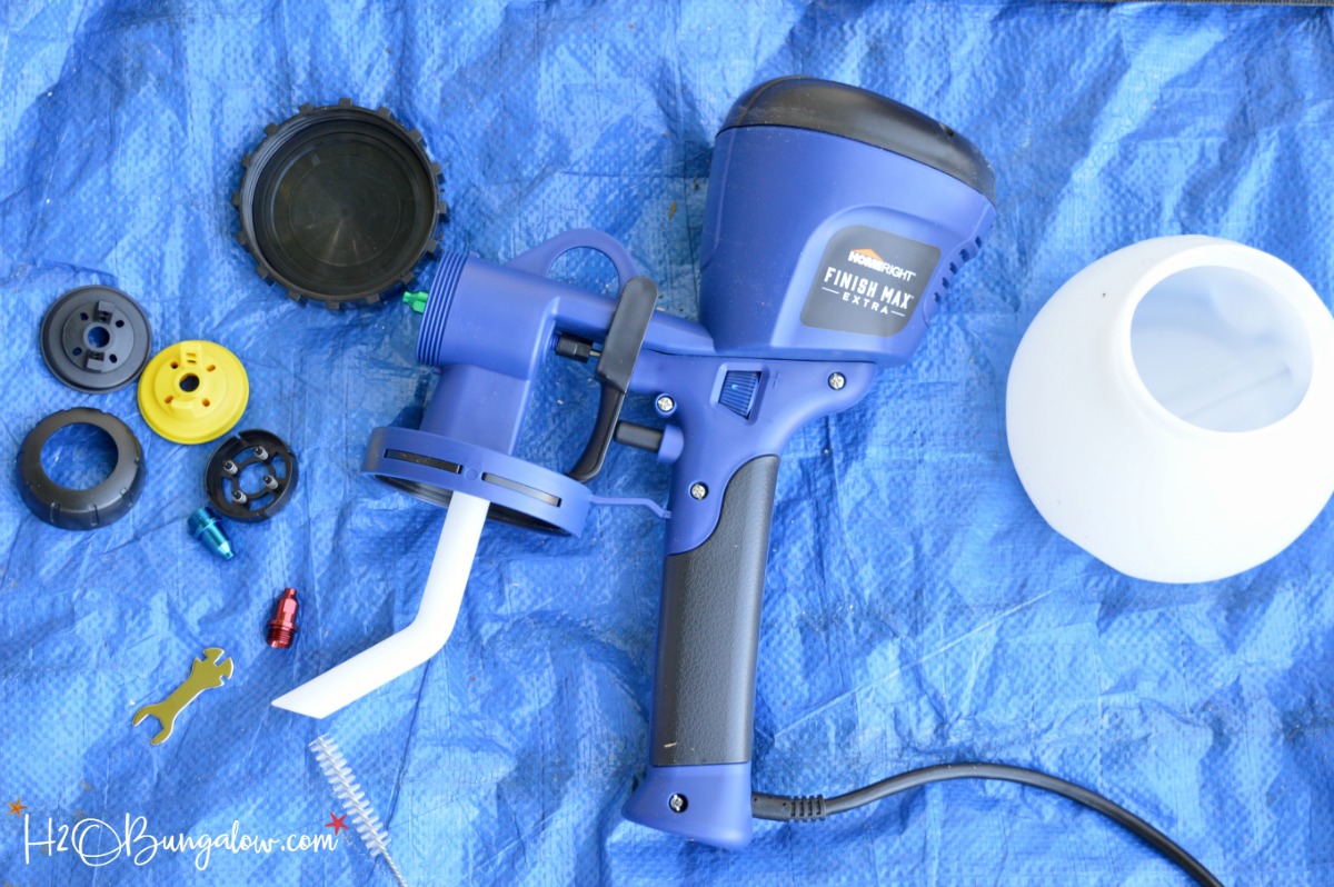 Homeright Finish Max paint sprayer and parts laying on a blue tarp