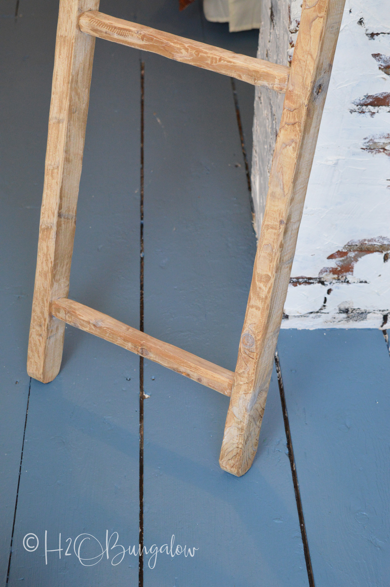 vintage ladder shown on painted wood floor