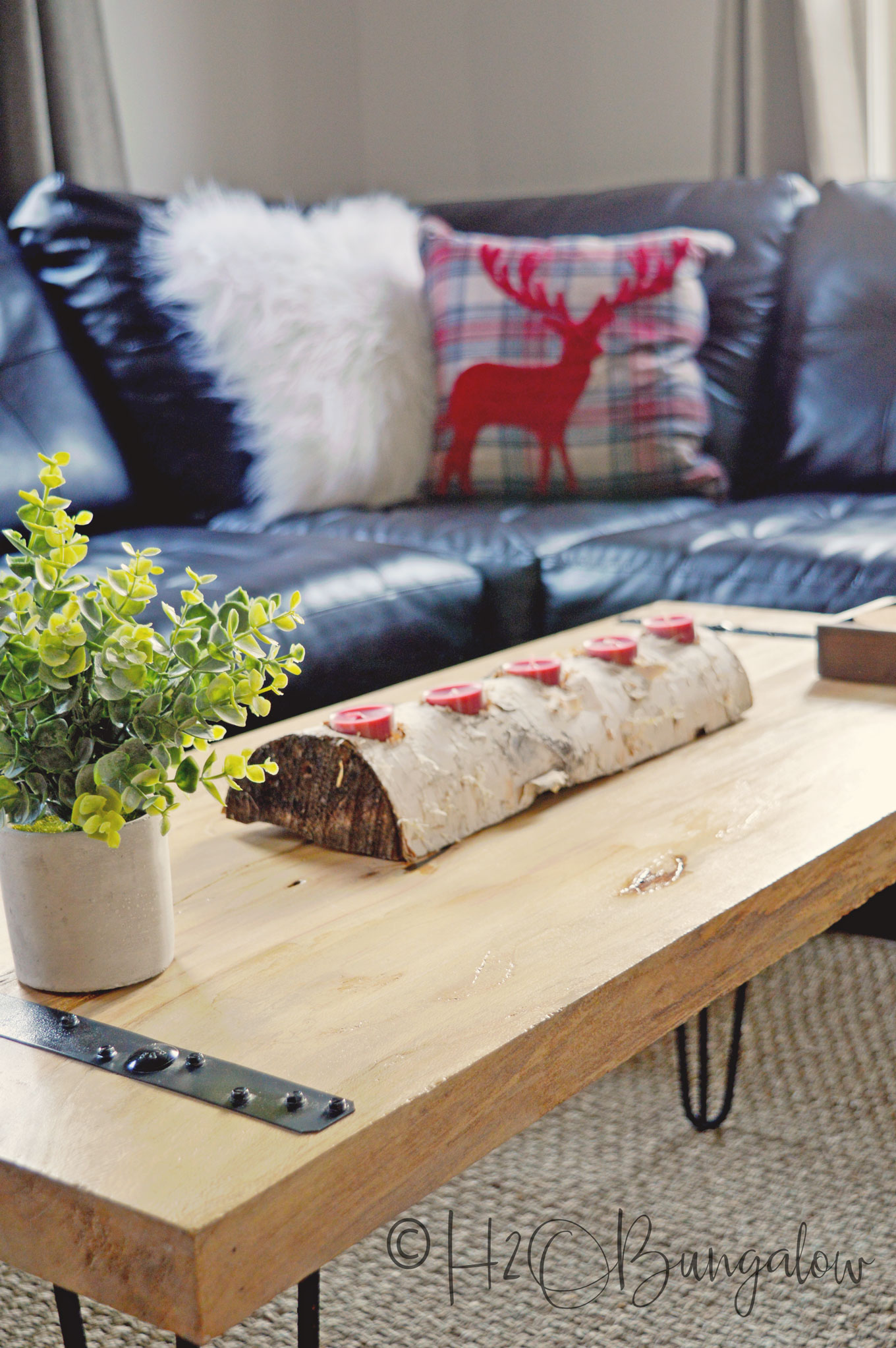 Birch log with five red tea lights sitting on wood coffee table