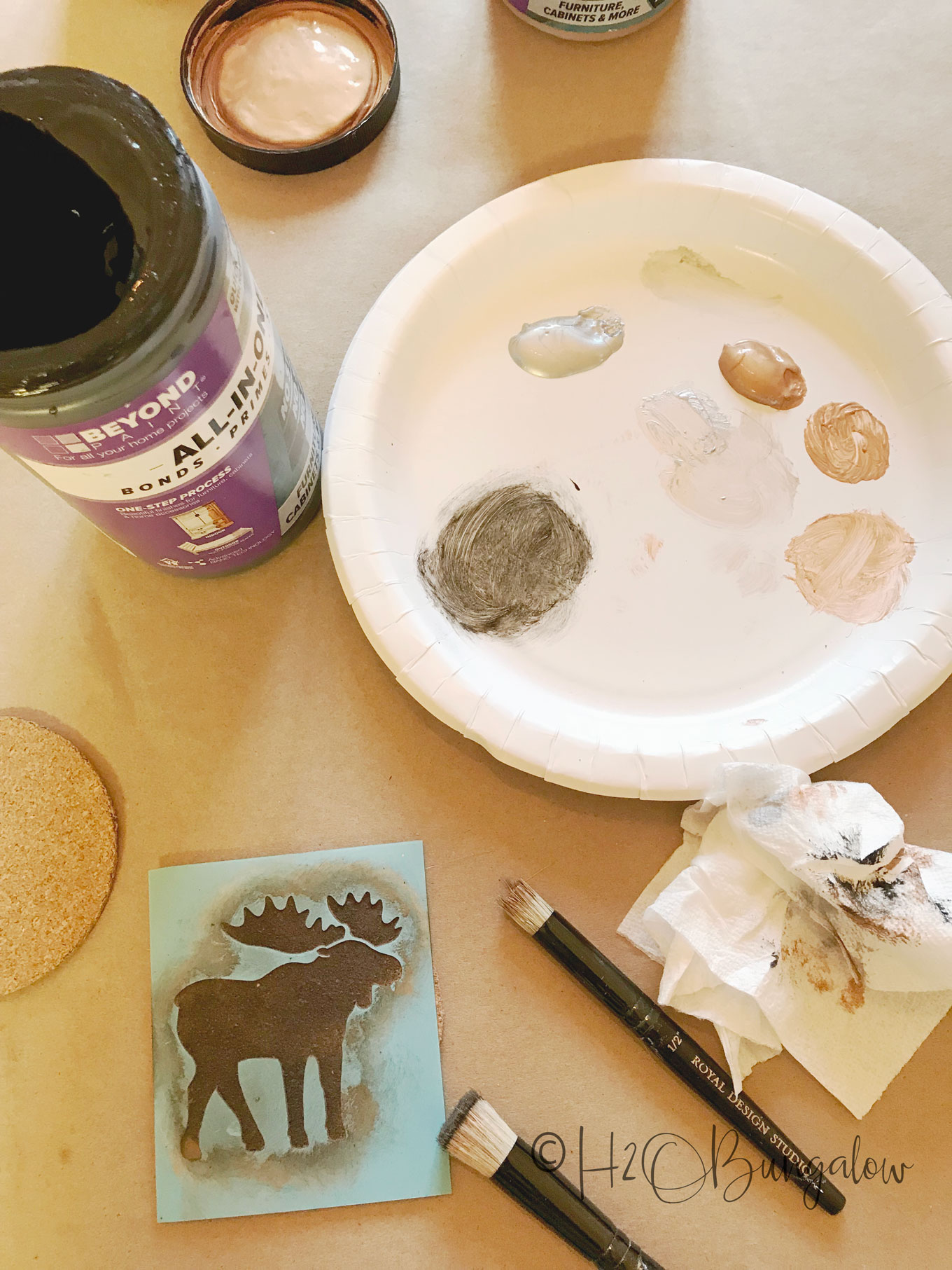 Paint colors on paper plate with moose stencil and small paintbush