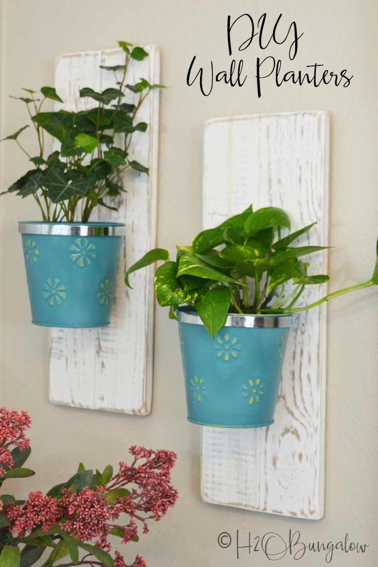 Easy tutorial for DIY wall hanging planters using dollar store items. I made a set of three hanging wall planters for my vine plants to cascade down. This is a great way to easily hang plants on walls. Hang your plants on walls, fences, outside walls or mount several on a board for a living wall. Also on this post, find more DIY craft projects using items from the Dollar Store from several other creative DIY bloggers.  #dollarstoreproject #dollarstoredesignsquad via @h2obungalow