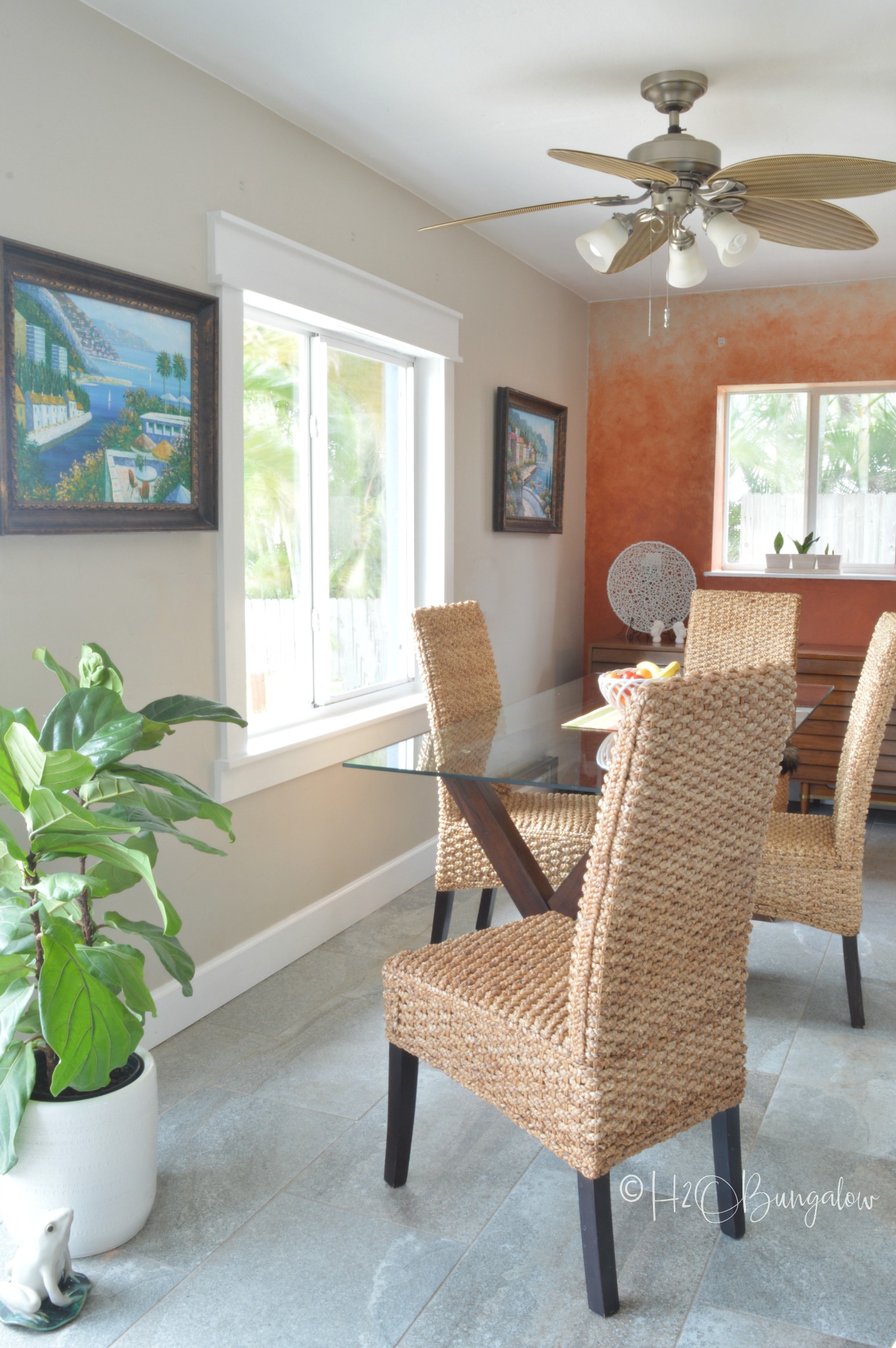 dining room shown with window trim and wicker chairs.