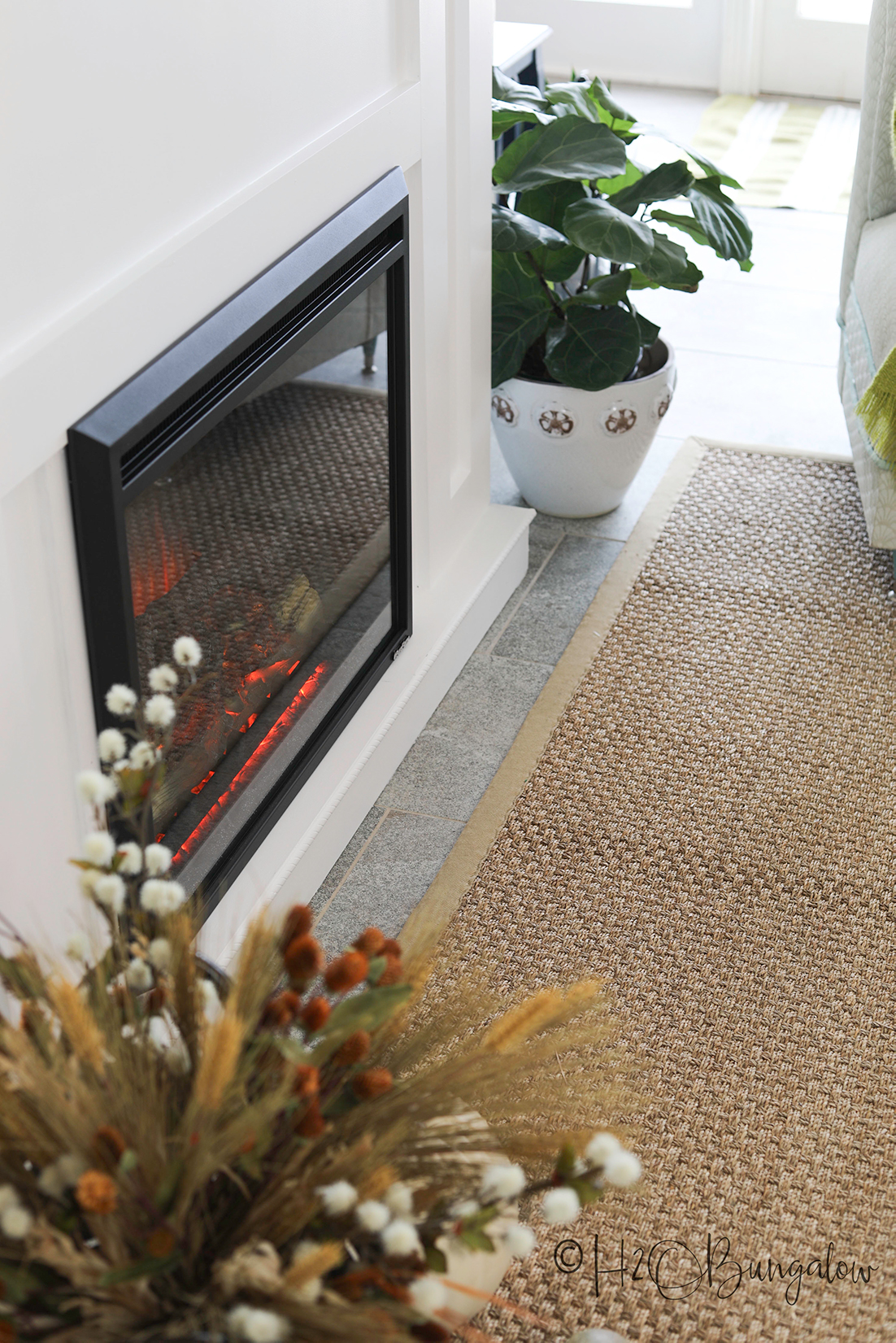 completed DIY white fireplace with an electric insert shown in living room with beige rug.