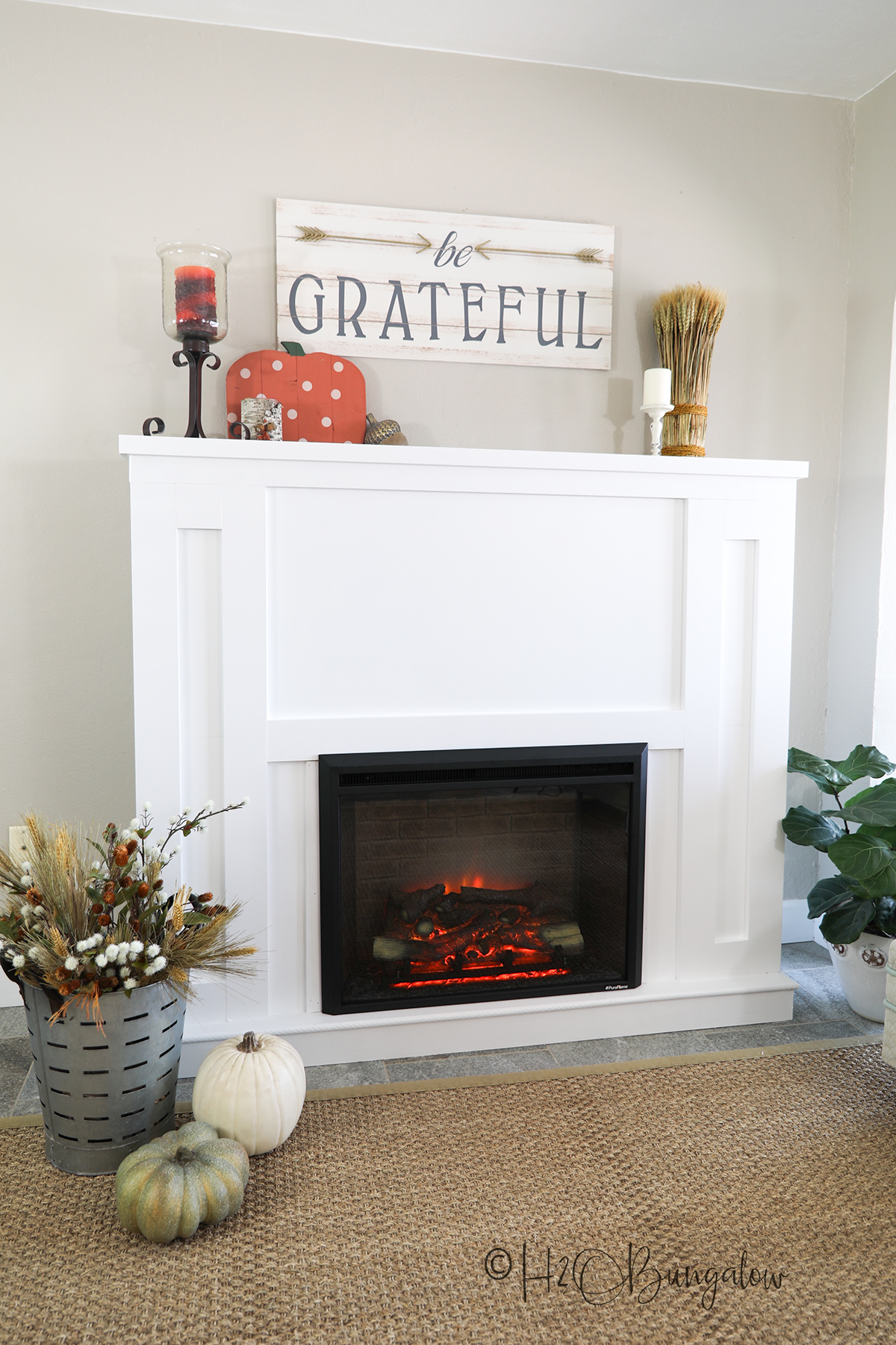 completed DIY fireplace with an electric insert shown with be grateful sign