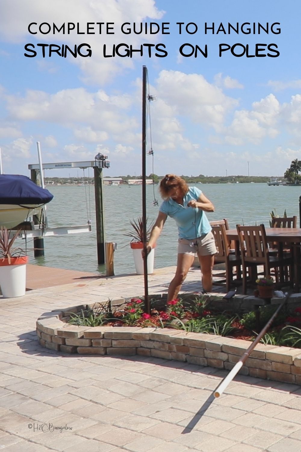 Wendi adding string lights on pole for outdoor seating area