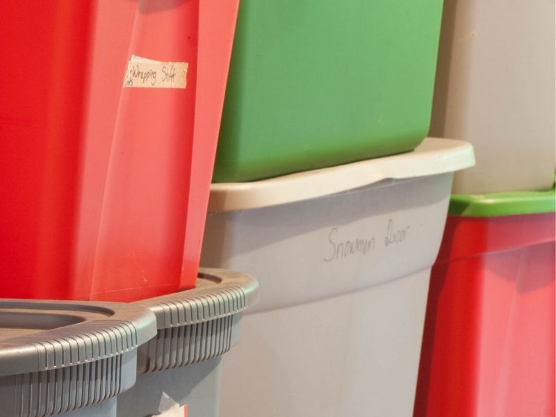 red, green, and gray plastic storage totes stacked 