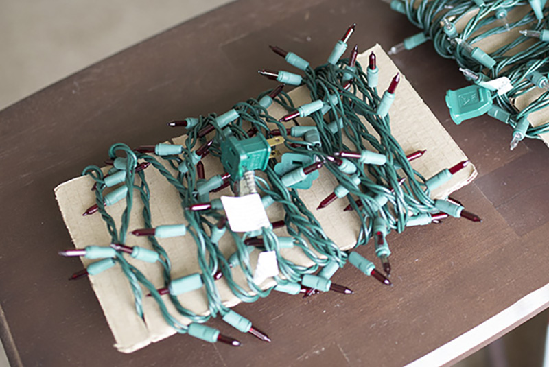 Christmas string lights wrapped on cardboard for storing