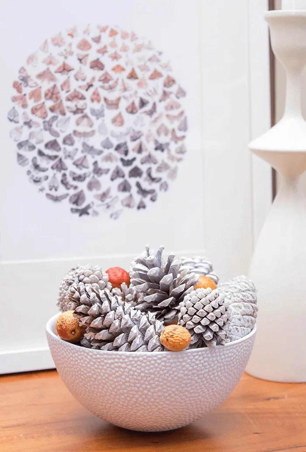 white painted bowel and pine cones
