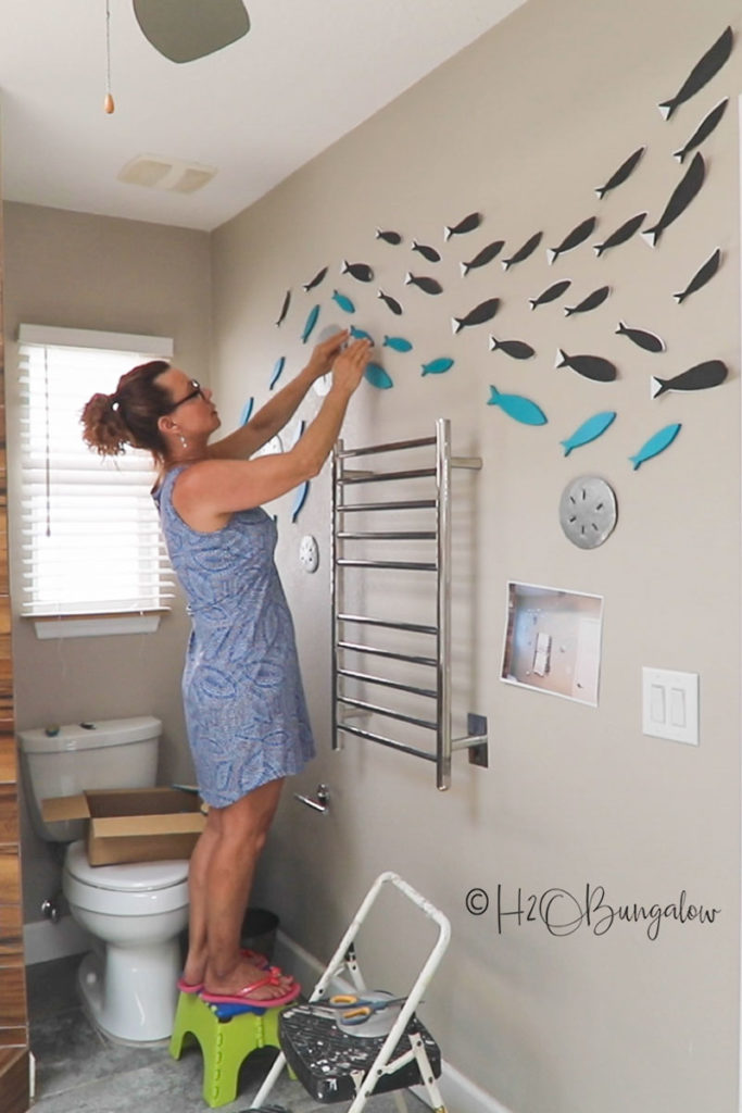 Making a wall mural with wooden fish cutouts 