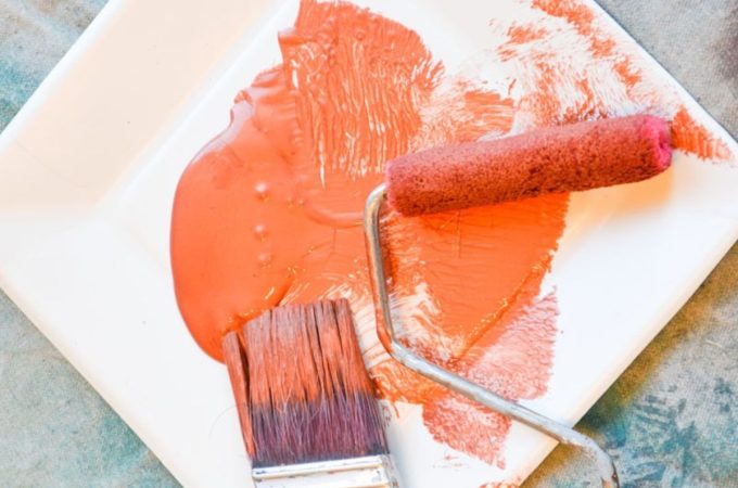 orange paint on paper plate with paint roller