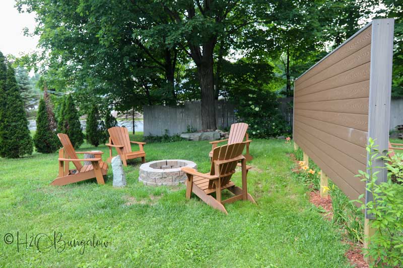 DIY outdoor privacy screen in yard with chairs and fire pit 