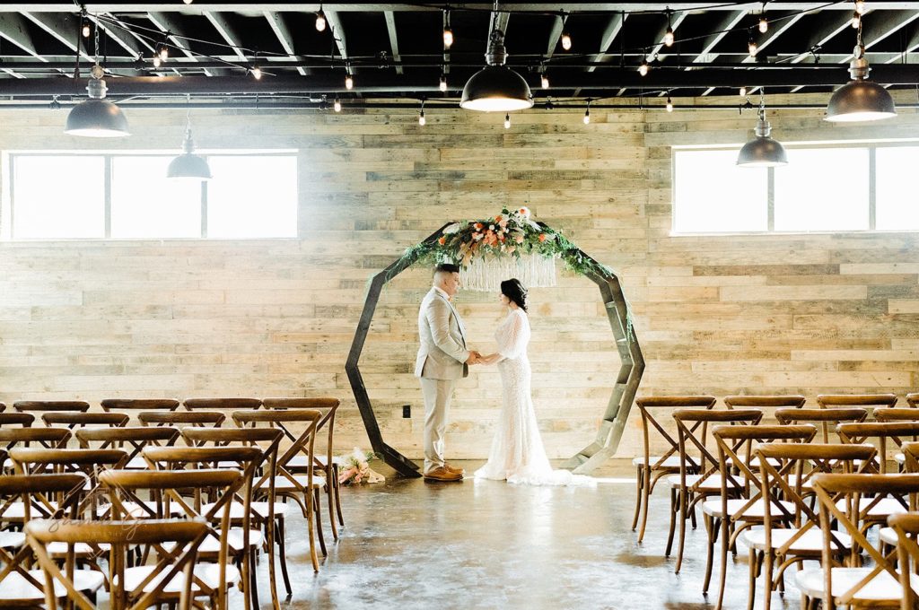 couple standing under DIY moon gate arch 