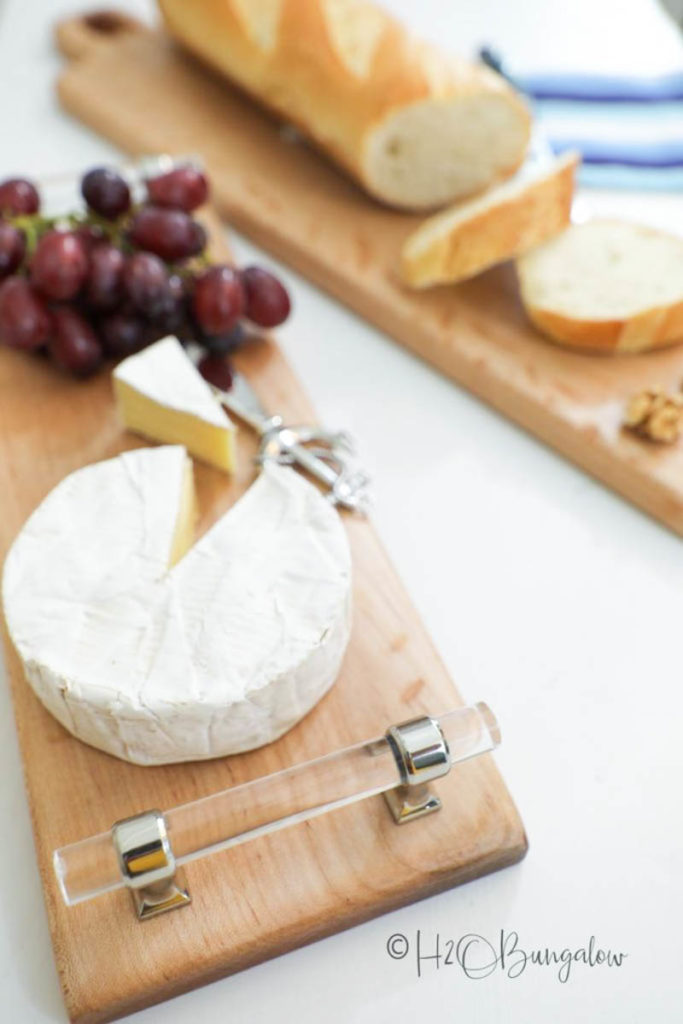 cheese, grapes and bread sitting on DIY chesse boards