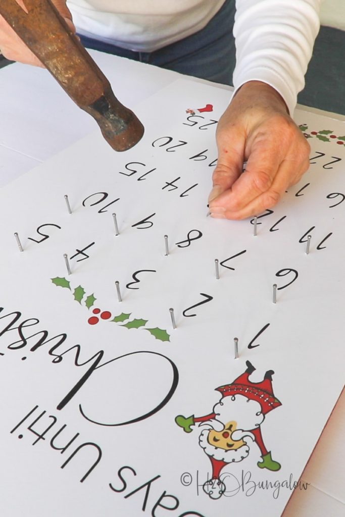 nailing ornament holders onto advent calendar 