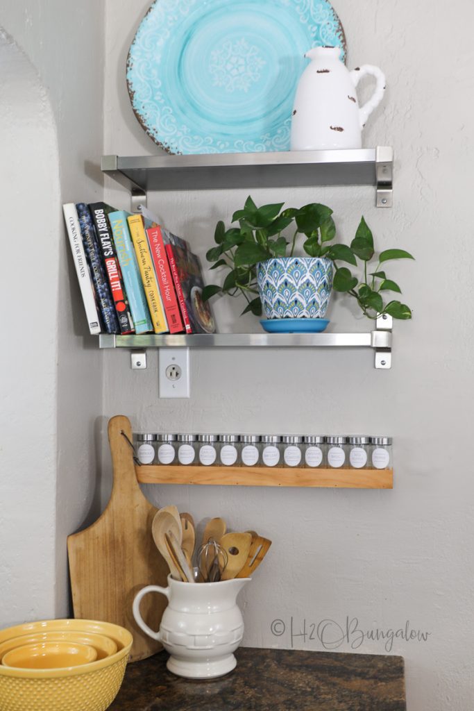 completed DIY wood spice rack with labeled spice jars on wall