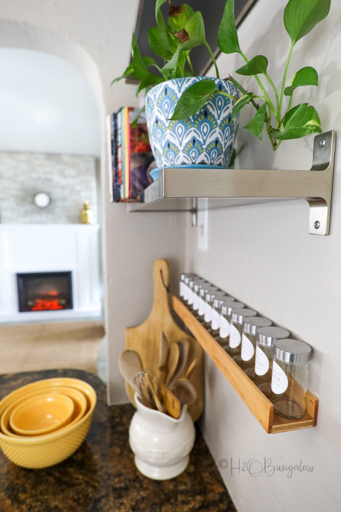 spice jars on handmade spice rack hanging on wall