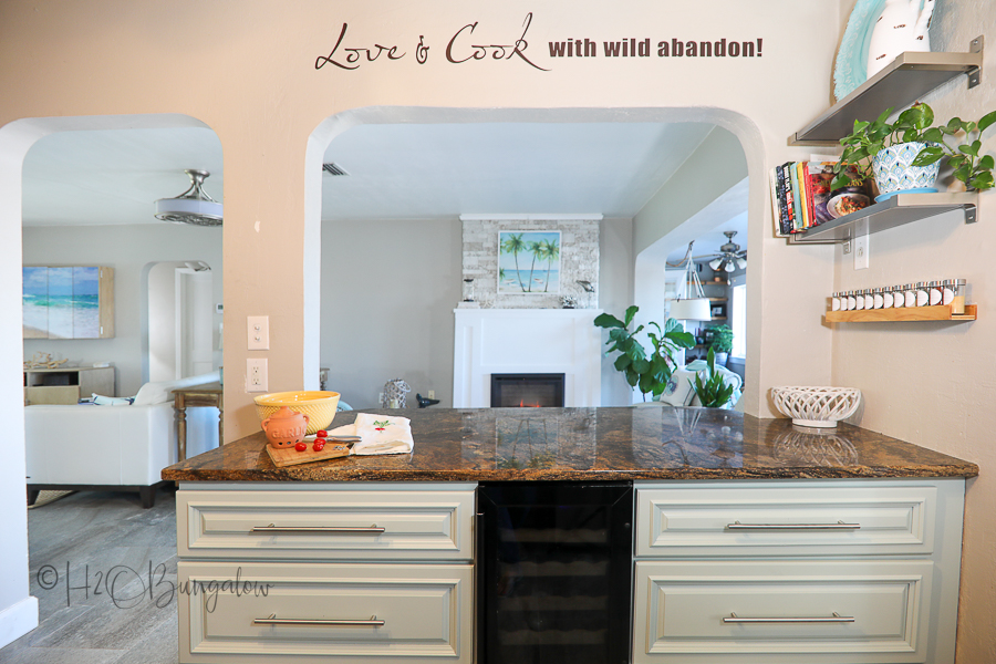 blue kitchen island overlooking fireplace in coastal home  