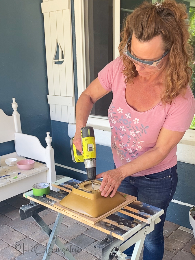 drilling drain holes in a ceramic container to plant plants in